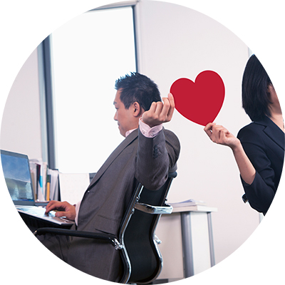 Work romance between two business people holding a heart
